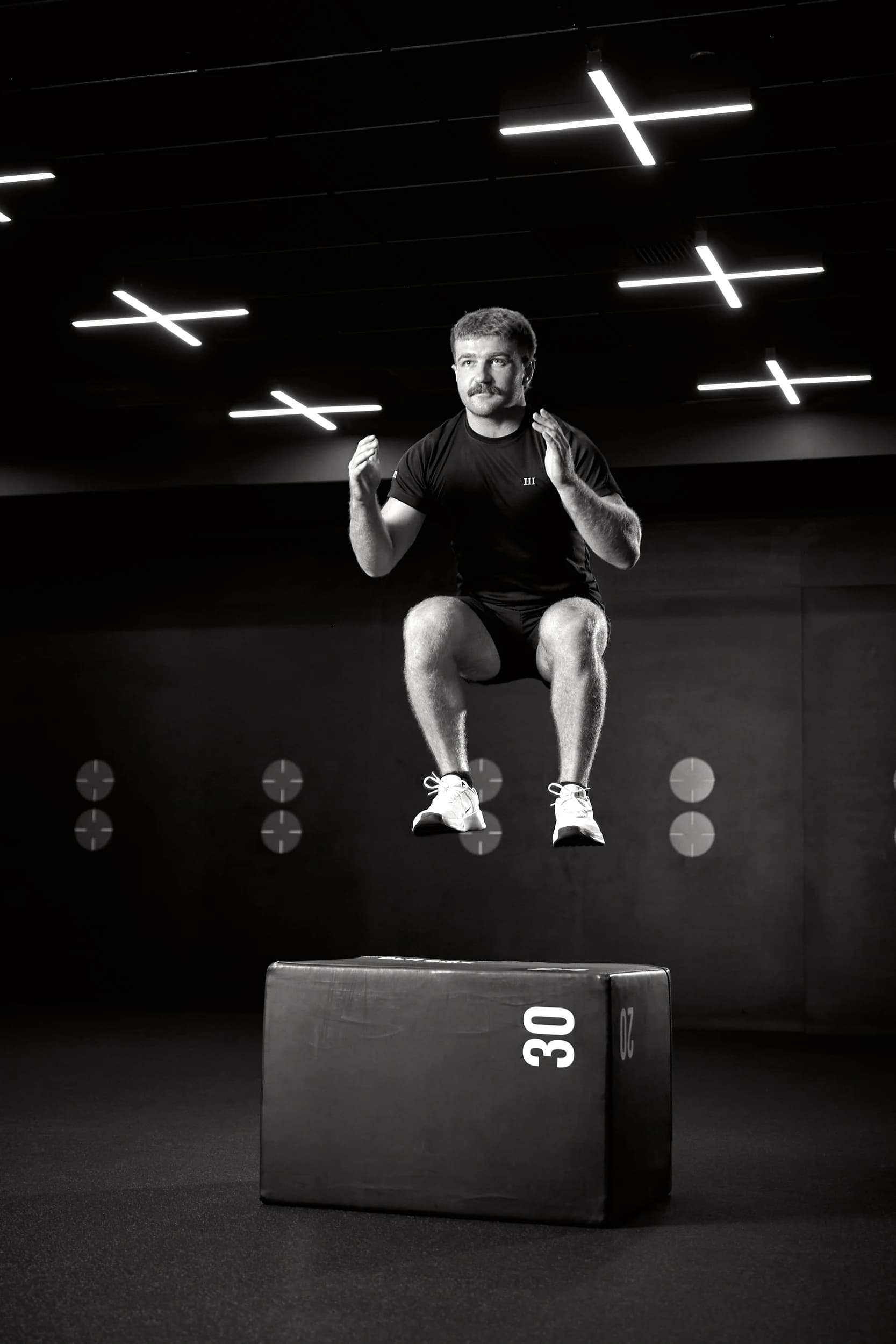 Josh Putt in a black polo standing in a luxury gym